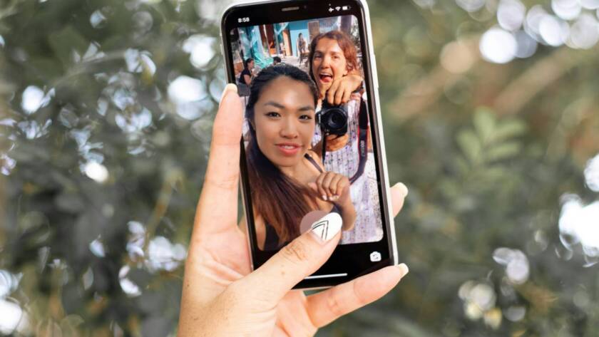 A girl and guy doing social media content on the phone.