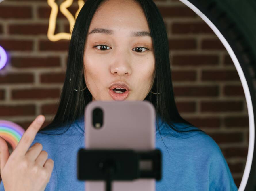 A girl doing a vlog in front of phone and ring light.